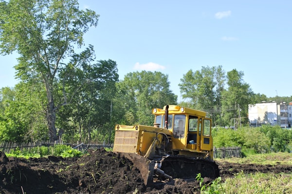 Heavy equipment performing site grading for residential drainage